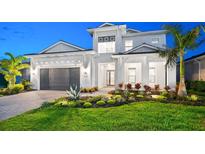 Stunning two-story home featuring a manicured lawn, lush landscaping, and a modern architectural design at 8163 Redonda Loop, Lakewood Ranch, FL 34202