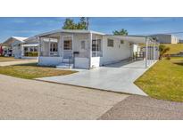 Charming single-story home featuring a screened front porch and covered carport on a sunny day at 1212 41St Avenue E Dr, Ellenton, FL 34222