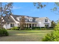 Charming two-story home featuring a landscaped yard, inviting front porch, and classic architectural details at 30416 Saddlebag Trl, Myakka City, FL 34251