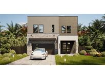 Modern two-story home featuring stone accents, a dark-colored garage door, and tropical landscaping in the front yard at 3811 30Th S Ave, St Petersburg, FL 33711