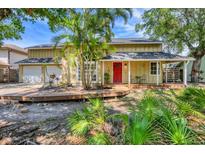 Charming two-story home with a well-maintained lawn, mature trees, front porch, and a two-car garage at 4063 Woodview Dr, Sarasota, FL 34232
