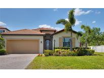 Beautiful one-story home with well-manicured lawn, paver driveway and tile roof, and lush landscaping at 4406 Baltry Ct, Bradenton, FL 34211