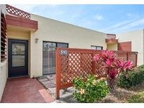 Charming condo featuring colorful foliage and decorative red lattice fencing around a private outdoor patio at 510 Spring Lakes Blvd, Bradenton, FL 34210