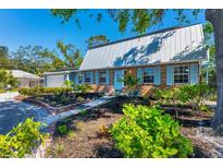Charming home featuring brick accents, a metal roof, an inviting front yard, and light blue shutters at 5404 4Th Avenue Nw Dr, Bradenton, FL 34209