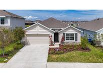 Inviting single-Gathering home featuring a two-car garage and a beautifully landscaped front yard at 5688 Woodland Sage Dr, Sarasota, FL 34238