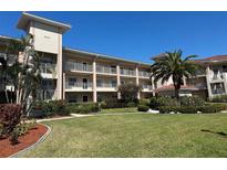 Beautiful condo building with multiple balconies, lush landscaping, and well-maintained lawn at 6501 Stone River Rd # 209, Bradenton, FL 34203