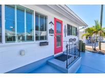 Home exterior showcasing a bright pink door, white exterior, and blue painted front patio area at 7 Braden Castle Dr, Bradenton, FL 34208
