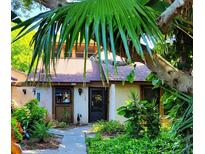 Charming home with a walkway lined with lush plants, leading to the front door underneath a tree at 7520 4Th W Ave # 1, Bradenton, FL 34209