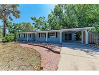 Charming single-story home featuring a covered carport, brick walkway and meticulously landscaped front yard at 826 Lillian Ln, Sarasota, FL 34243