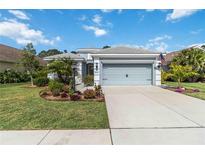 Charming home with a well-manicured lawn, an attached two car garage, and attractive landscaping at 12272 Stuart Dr, Venice, FL 34293
