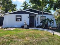 Charming single story home with a landscaped front yard and walkway leading to the front door at 1854 Debbie St, Sarasota, FL 34231