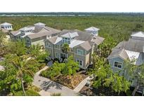 An aerial view of the house shows its location with mature landscaping and nearby water at 275 Sapphire Lake Dr # 101, Bradenton, FL 34209