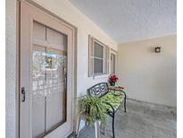The front door is shown with charming bench seating and greenery at 2839 Swifton Dr # 28, Sarasota, FL 34231