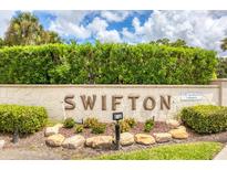 Stone sign surrounded by shrubbery marks Swifton, a 55+ age-restricted community at 2839 Swifton Dr # 28, Sarasota, FL 34231