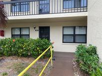 Inviting front entrance of unit 112 featuring a well-manicured garden and a secure entry door at 425 30Th W Ave # C112, Bradenton, FL 34205