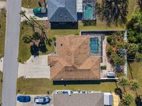 Aerial view of a single-Gathering home with a backyard pool and landscaped yard surrounded by lush greenery and neighboring houses at 4655 Payne St, North Port, FL 34287