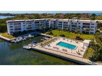 Stunning aerial view of waterfront condos with a pool, boat docks, and lush landscaping at 605 Sutton Pl # 401-A, Longboat Key, FL 34228