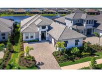Beautiful single Gathering home with elegant architecture, manicured landscaping, and a brick driveway at 8335 Sea Glass Ct, Sarasota, FL 34240