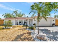 Charming single-story home with well-manicured landscaping and a welcoming front porch, with a two car garage at 8419 Sylvan Woods Dr, Sarasota, FL 34243