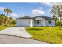 Charming single-story home featuring a two-car garage, well-manicured lawn, and welcoming curb appeal at 102 Arrow Ln, Rotonda West, FL 33947