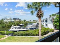 Picturesque waterfront view featuring boat docks, lush greenery, and blue skies from a serene balcony at 1233 Dockside Pl # 207, Sarasota, FL 34242