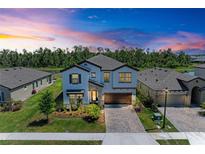 Stunning two-story home with a brick driveway, lush landscaping, and a two-car garage at 12664 Oak Hill Way, Parrish, FL 34219