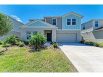 Two-story home featuring a concrete driveway, well-kept lawn, and a two-car garage at 12738 Hysmith Loop, Parrish, FL 34219