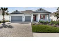 Charming single-story home featuring a two-car garage and a beautifully landscaped front yard at 1596 Laurel Brook Ln, Port Charlotte, FL 33953