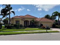 Beautiful single-story home with a red tile roof, lush landscaping, and an attached two-car garage at 193 Montelluna Dr, North Venice, FL 34275