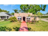 Charming single-Gathering home showcasing a quaint exterior with a red tile walkway and well-maintained lawn at 229 42Nd W St, Bradenton, FL 34209