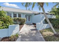 Charming home featuring a blue exterior, lovely landscaping, and a welcoming walkway to the front door at 23116 Amethyst Ave, Port Charlotte, FL 33952