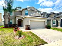 Charming two-story home with well-manicured lawn, large driveway, and a two car garage at 2332 Dovesong Trace Dr, Ruskin, FL 33570