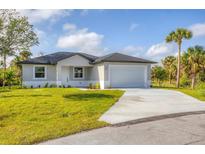 New single-story home features a two-car garage, modern design, and fresh landscaping at 405 Sunset N Rd, Rotonda West, FL 33947