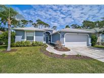 Charming single Gathering home featuring a well-manicured lawn, mature trees, and an attached two-car garage at 4146 Westbourne Cir, Sarasota, FL 34238
