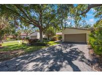 Charming single-Gathering home featuring a two-car garage and mature trees shading the front yard at 6407 Quail Hollow Pl, Bradenton, FL 34210