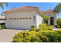 Charming home featuring a two-car garage, lush landscaping, and a beautifully tiled roof at 7159 Westhill Ct, Lakewood Ranch, FL 34202