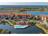 Aerial view of waterfront condos, community pool, and lush landscaping in a desirable location at 7710 Lake Vista Ct # 407, Lakewood Ranch, FL 34202