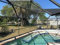 Screened-in pool with pristine water and a canal view on a sunny day at 108 Martin Ne Dr, Port Charlotte, FL 33952