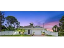 Charming single-Gathering home featuring a well-manicured lawn, vinyl fence and a two-car garage at 13339 Flaherty Ave, Port Charlotte, FL 33981