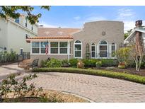 Charming stucco home featuring a brick driveway, manicured landscaping, and an inviting front porch at 4109 Riverview Blvd, Bradenton, FL 34209