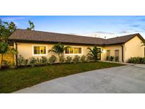Charming single-story home featuring manicured landscaping, well-lit windows, and a freshly paved driveway at 5247 Carmilfra Dr, Sarasota, FL 34231