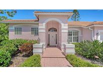 Charming pink home featuring a covered front entrance and beautifully landscaped garden at 5270 Far Oak Cir, Sarasota, FL 34238