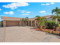 Charming single-story home featuring a wide driveway, lush landscaping and a two car garage at 5563 America Dr, Sarasota, FL 34231