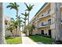 Beautiful condominium exterior with palm trees, lawn and walkways in a tropical paradise at 5963 Midnight Pass Rd # 355, Sarasota, FL 34242