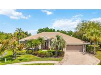Charming home featuring a tile roof, well-manicured landscaping, and a brick-paved driveway leading to a two-car garage at 6222 Stillwater Ct, Bradenton, FL 34201