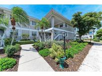 Beautiful condo building featuring mature landscaping, green lawns and a private entrance staircase at 628 Estuary Dr, Bradenton, FL 34209