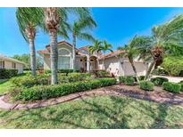Charming home with well-manicured landscaping, lush green lawn and mature palm trees at 6324 41St E Ct, Sarasota, FL 34243