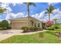 Charming single-story home featuring a two-car garage, lush landscaping, and well-maintained lawn at 7710 Seven Oaks Dr, Bradenton, FL 34201