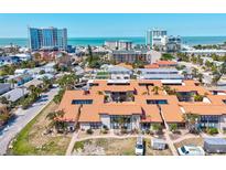 Beautiful aerial view of condo community near beach with turquoise water and city buildings on the horizon at 800 S Blvd Of The Presidents # 3, Sarasota, FL 34236