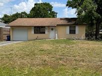 Charming single story home featuring a well manicured lawn, attached garage, and classic curb appeal at 831 Bacon Ave, Sarasota, FL 34232